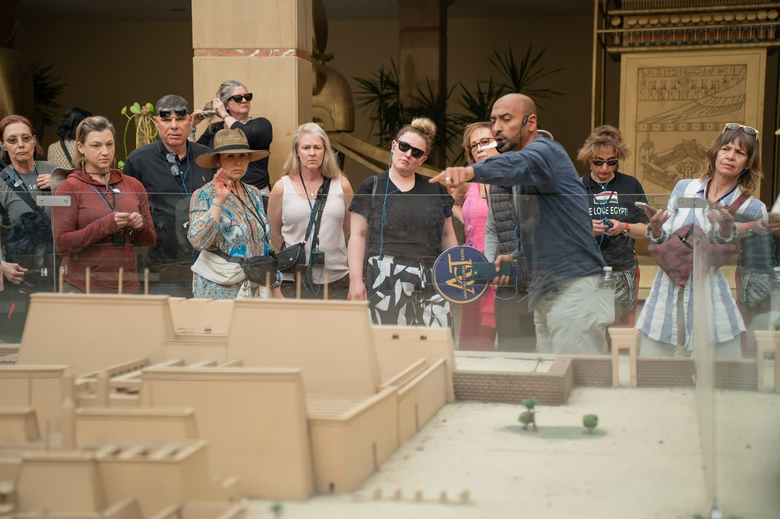 A guide explaining a temple model to a group of travellers